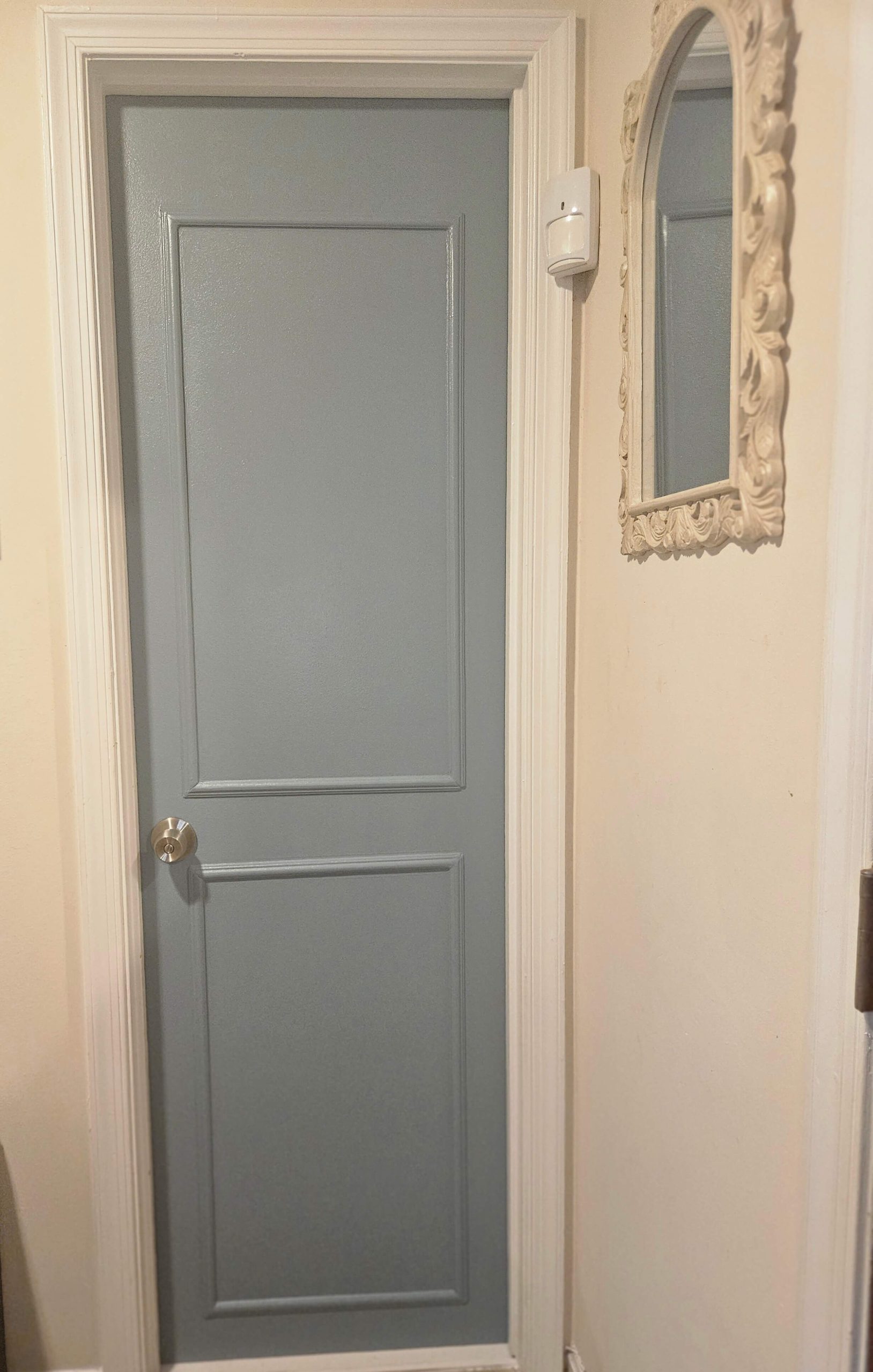 Picture of a hollow core door that has been updated by adding trim and painting it a blue color with a hint of grey